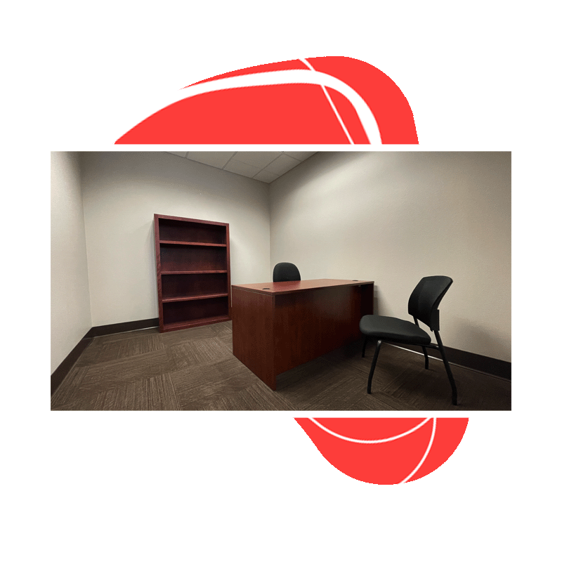A single person office with a desk, chair for meetings, and bookcase for storage.